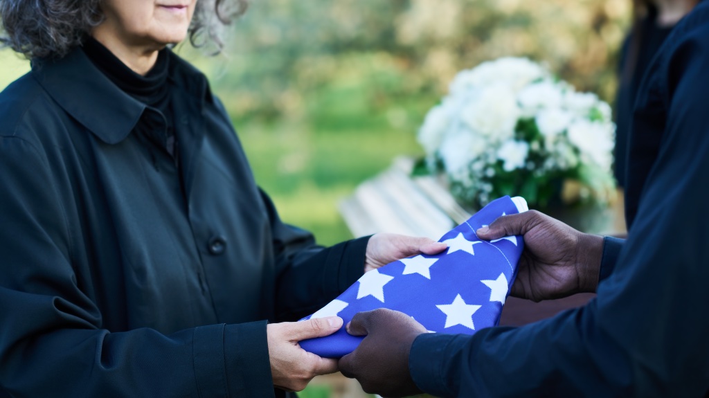 Person giving American flag to another person